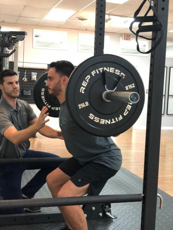 Physical therapist assisting patient's strength training