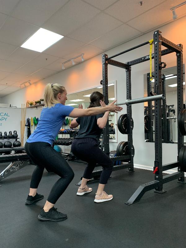 Physical therapist assisting patient's strength training